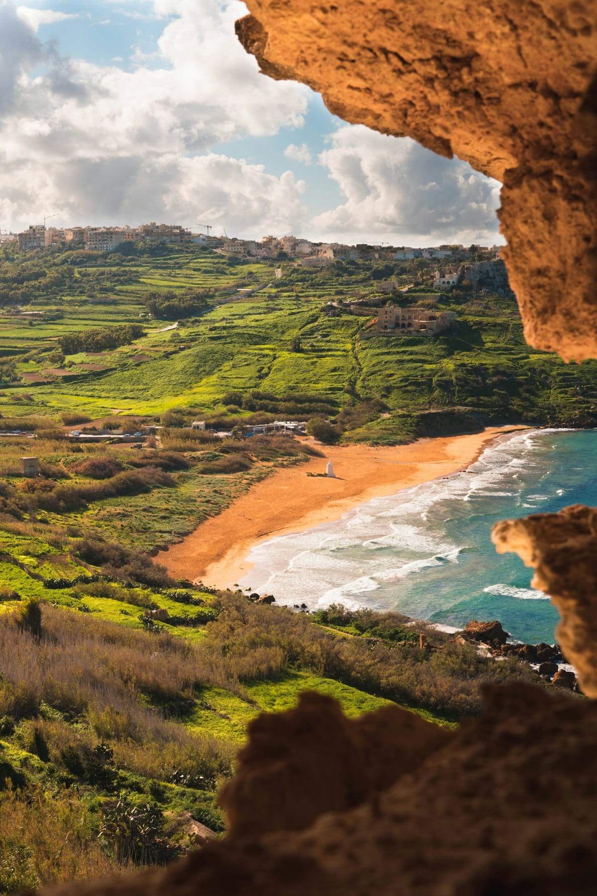 View of Ramla Bay and green terraced hills from Calypso Cave in Gozo